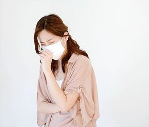 マスクをして咳込む女性