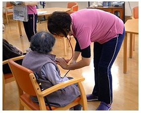 スタッフが利用者さまの血圧を測る健康チェック
